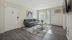 Una sala de estar moderna con un sofá gris, una mesita de centro y un cuadro en la pared.