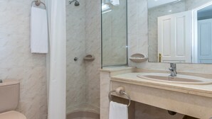A bathroom with a toilet, a shower, a sink, and a mirror. - Aparthotel Ona Alanda club, luxury.40 meters from the beach.spectacular views. (Marbella)