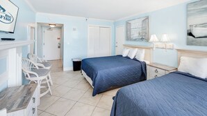 A hotel room with two beds, a chair, a desk, and a television. - Oceanfront Studio - Indoor Pools, Hot Tubs, Nice! (Myrtle Beach)
