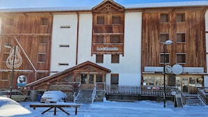 En bygning med en træfacade, et skilt med 'Le Chamois' og et skilt der siger 'SNACK BAR'.