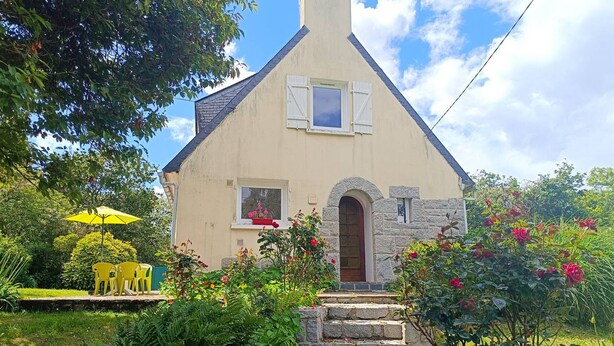 A quaint house with a stone staircase leading to a wooden door, surrounded by lush greenery and flowering plants. - Charming House near Beach with WIFI, Garden & Terrace - Pleumeur-Bodou (Pleumeur-Bodou)