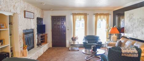A living room with a fireplace, a television, a sofa, and a coffee table.