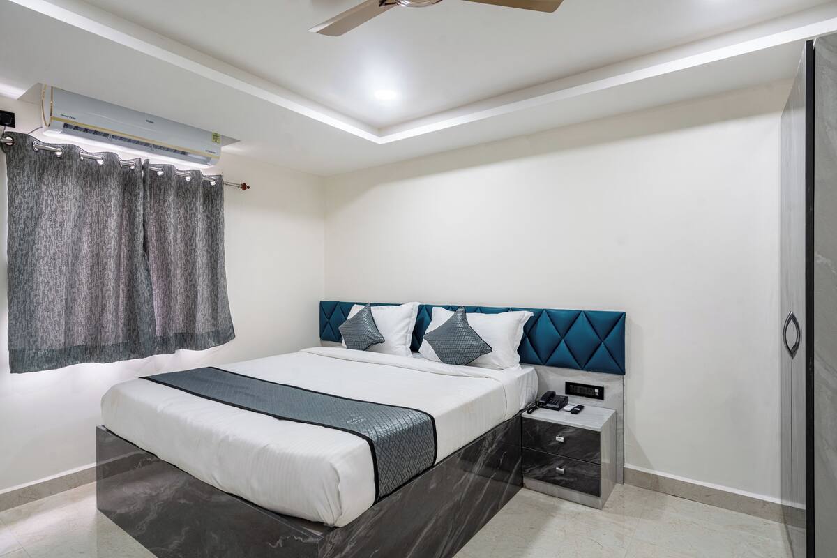 Un dormitorio moderno con cama, mesita de noche y equipo de aire acondicionado.