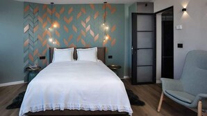 A bedroom with a bed, a chair, a wall with a geometric pattern, and a door. - Amazing Sea View Stylish 1BR | Safe Room on Floor (Herzliya)