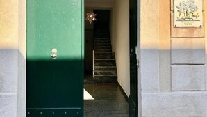 A green door with a star-shaped light fixture above it, leading to a staircase. - Don Carlo Tropea (Tropea)