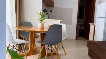 Un espacio habitable compacto con comedor, kitchenette y sofá.