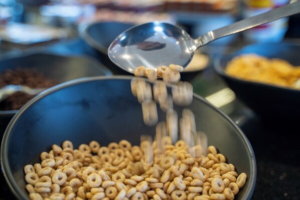 A spoonful of cereal being poured into a bowl.