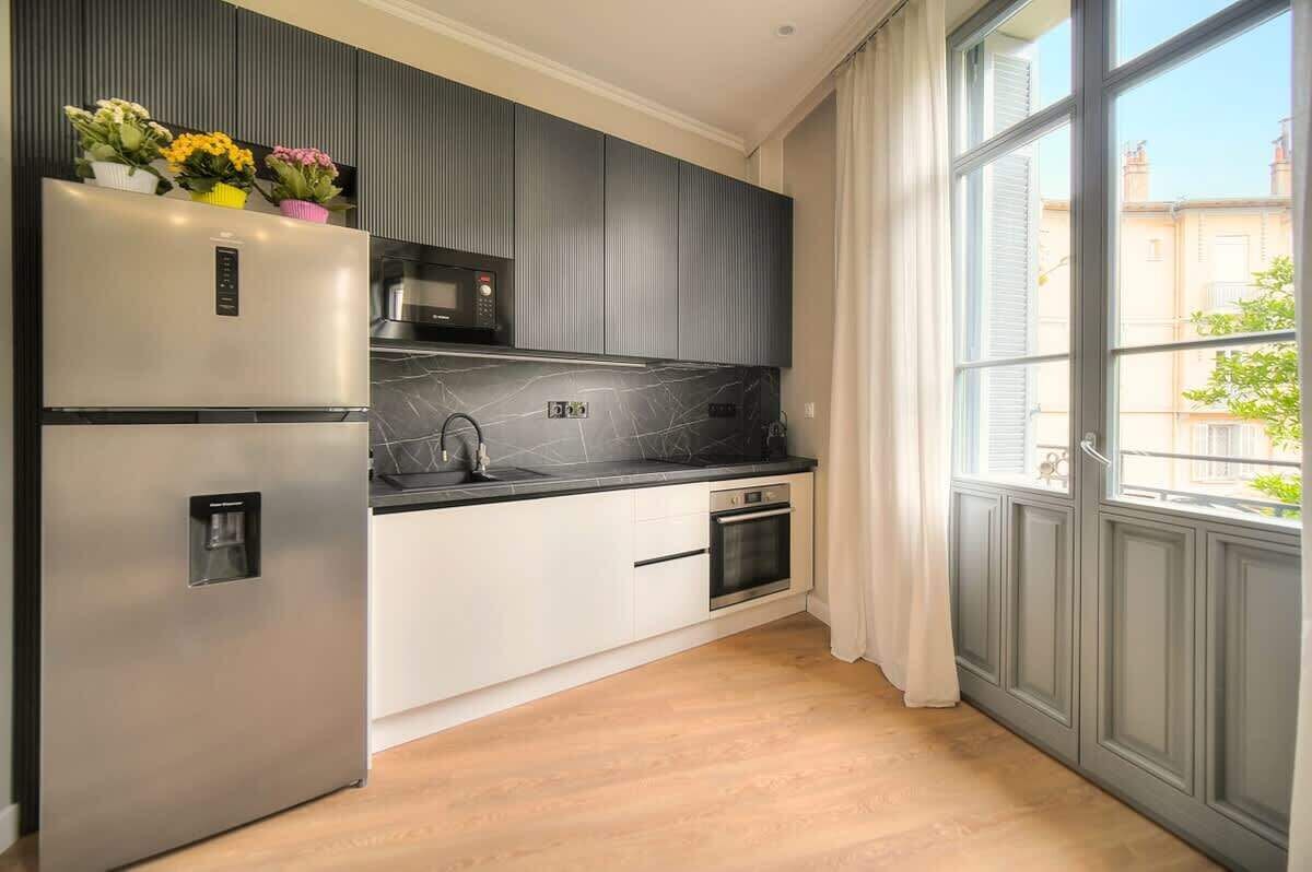 Een moderne keuken met een roestvrijstalen koelkast, een magnetron en een inbouwoven.