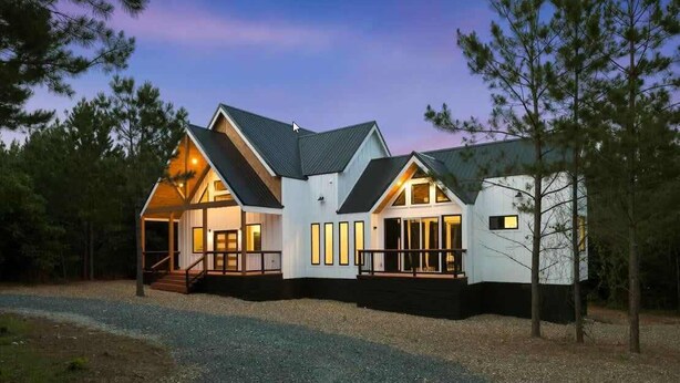 A modern house with a prominent front porch, large windows, and a steeply pitched roof. - Entertainment Cabin Retreat, Spa Games & Play Zone (Broken Bow)