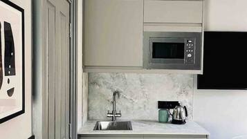 Kühlschrank, Mikrowelle, Herdplatte, Wasserkocher mit Kaffee-/Teezubehör