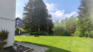 Ein Garten mit Rasen, einer Spielanlage und einem Geräteschuppen.
