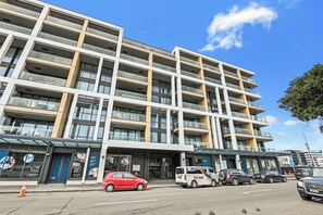 A multi-story building with a modern architectural design, featuring balconies and large windows. - Wynyard Quarter Apartments by Urban Rest (Auckland)