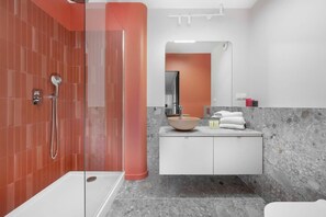 Enjoy a refreshing shower in the glass-enclosed shower area with a sleek showerhead.