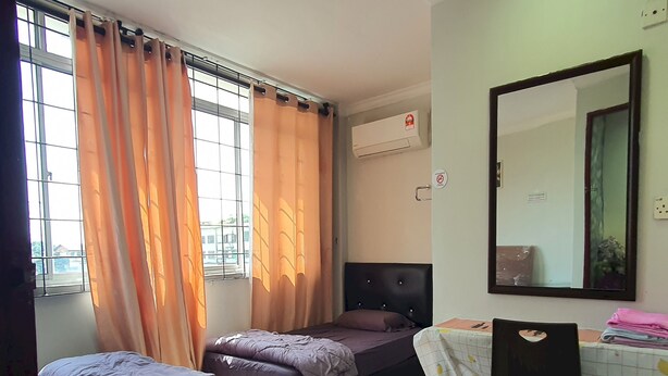 Una habitación con dos camas, un escritorio, una silla, un espejo y una ventana con cortinas.