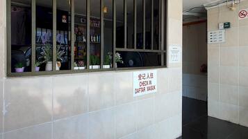 A check-in counter with a sign indicating room numbers 101-103, 200-208, 300-308, and 500-508.