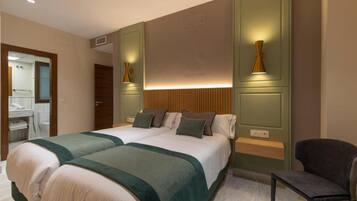 Ein Hotelzimmer mit zwei Betten, einem Sessel und einem Spiegel.