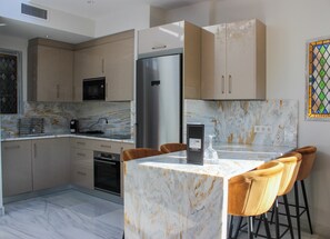 Apartamento superior, 2 quartos | Cozinha privada | Geladeira, micro-ondas, cooktop, cafeteira/chaleira