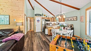 A cozy cabin interior with a living room, dining area, and kitchen.