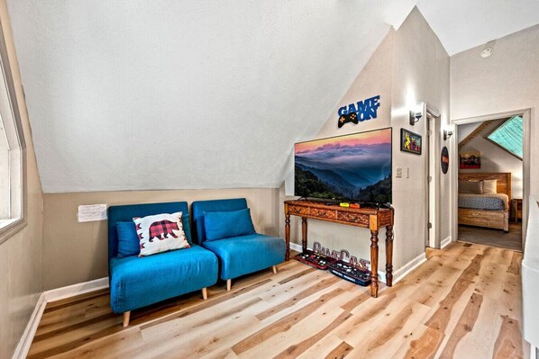 A cozy room with a blue sofa, a wooden coffee table, and a TV on a stand.