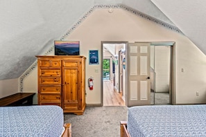 A bedroom with two beds, a wooden dresser, a fire extinguisher, and a door leading to another room. - 5 Mins to Gatlinburg*Hot Tub+Resort Pool/Amenities (Gatlinburg)