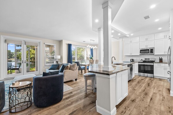 A modern kitchen with white cabinets, a central island, and stainless steel appliances.