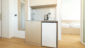 A compact kitchen with a coffee maker, a mini-fridge, and a mirror. - Millennia Hotel (Sofia)