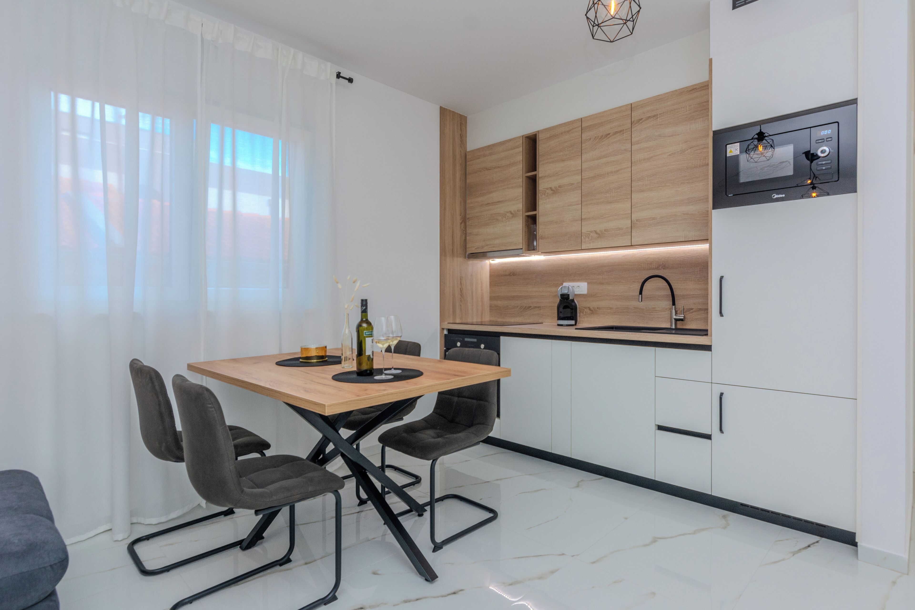 A modern kitchen with wooden cabinets, a built-in oven, and a coffee machine.