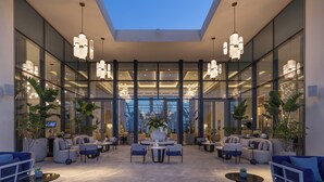 A spacious lobby with modern furniture, large windows, and decorative lighting. - Address  Beach Resort Marassi (El Alamein)