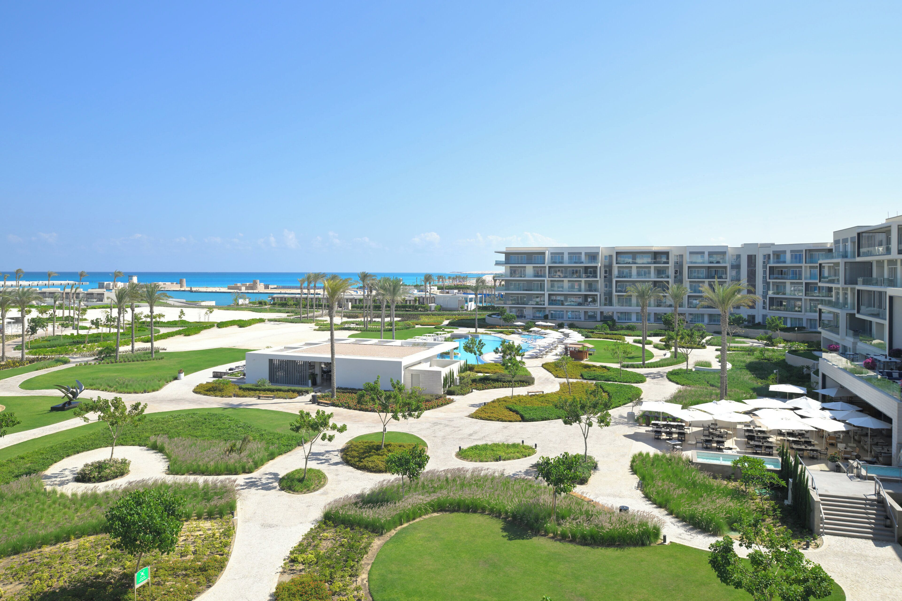Un complejo turístico con varias construcciones, una piscina y una zona de playa.