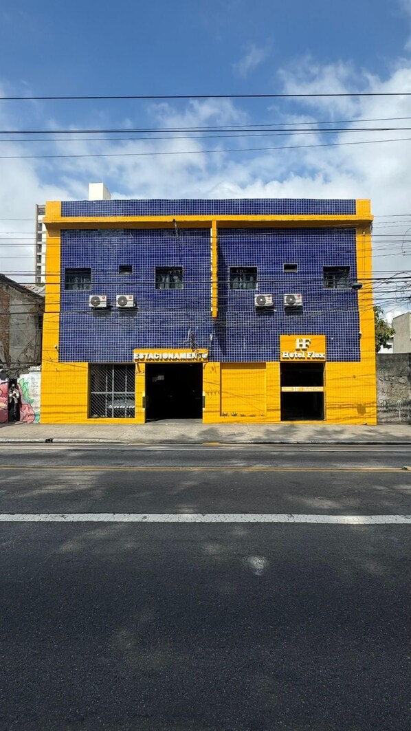 A building with a blue and yellow facade, featuring two entrances labeled "HOTEL FLEX" and "HOTEL FLEX." - Hotel Flex Tatuapé  (Sao Paulo)