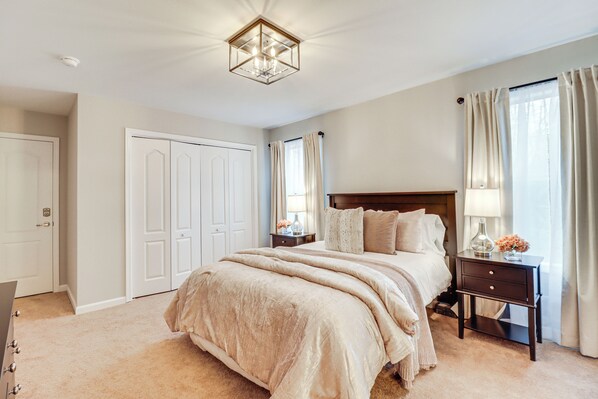 Quarto com uma cama grande, mesa de cabeceira, penteadeira e armário.