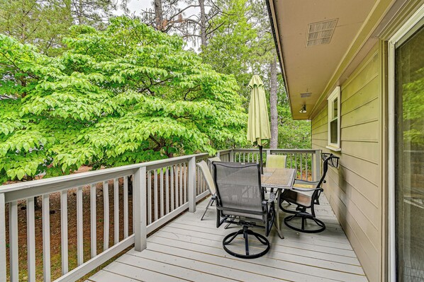 A wooden deck with a white railing, two chairs, and a table. - < 2 Mi to Golf Course: Pinehurst Home w/ Deck! (Pinehurst)
