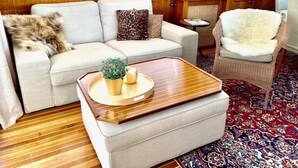 A cozy living room with a sofa, a chair, a coffee table, and a patterned rug. - Lilla Mälardrottningen (Stockholm)