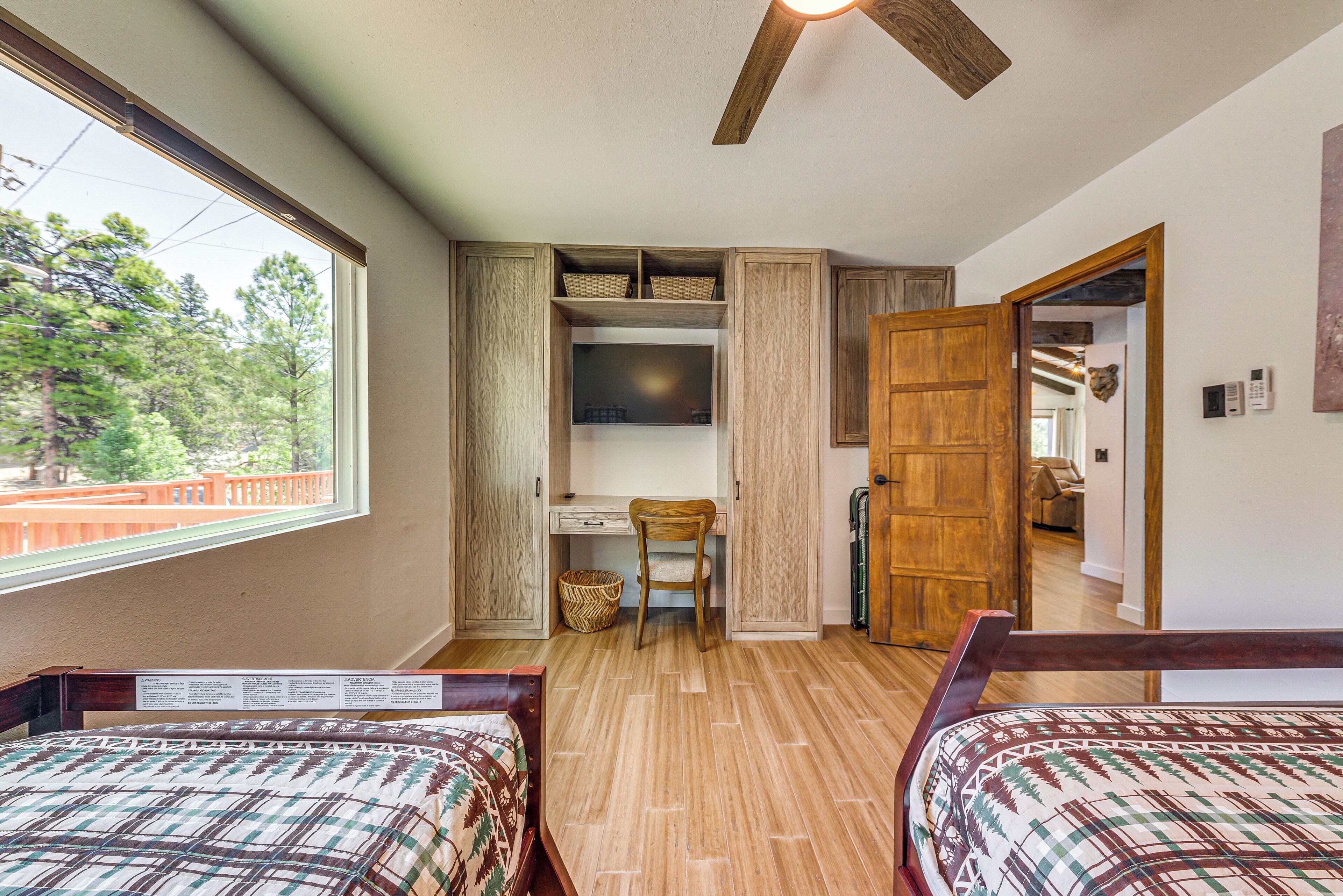 Een slaapkamer met twee bedden, een bureau en een kledingkast.