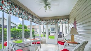A sunroom with wicker chairs, a table, and a ceiling fan. - Discover Your Perfect Summerhill Retreat with 2-Bed, 2-Bath, and Golf Cart! (The Villages)