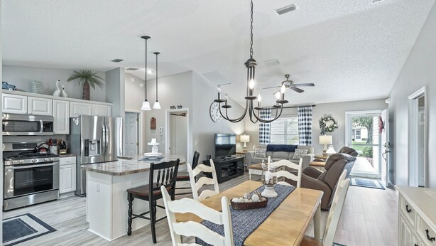 A spacious kitchen with modern appliances and a dining area with a large island. - Discover Your Perfect Summerhill Retreat with 2-Bed, 2-Bath, and Golf Cart! (The Villages)