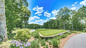 A golf course with a stone wall, manicured lawn, and purple flowers. - Golf Gem in Trillium Links 1 Mi to Cashiers (Cashiers)