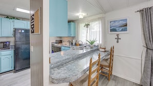 Una cocina con encimera de granito, refrigerador y armarios azul claro.