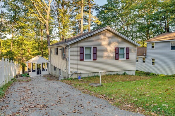 A single-story house with a covered porch, a small attached garage, and a front yard with a gravel path.