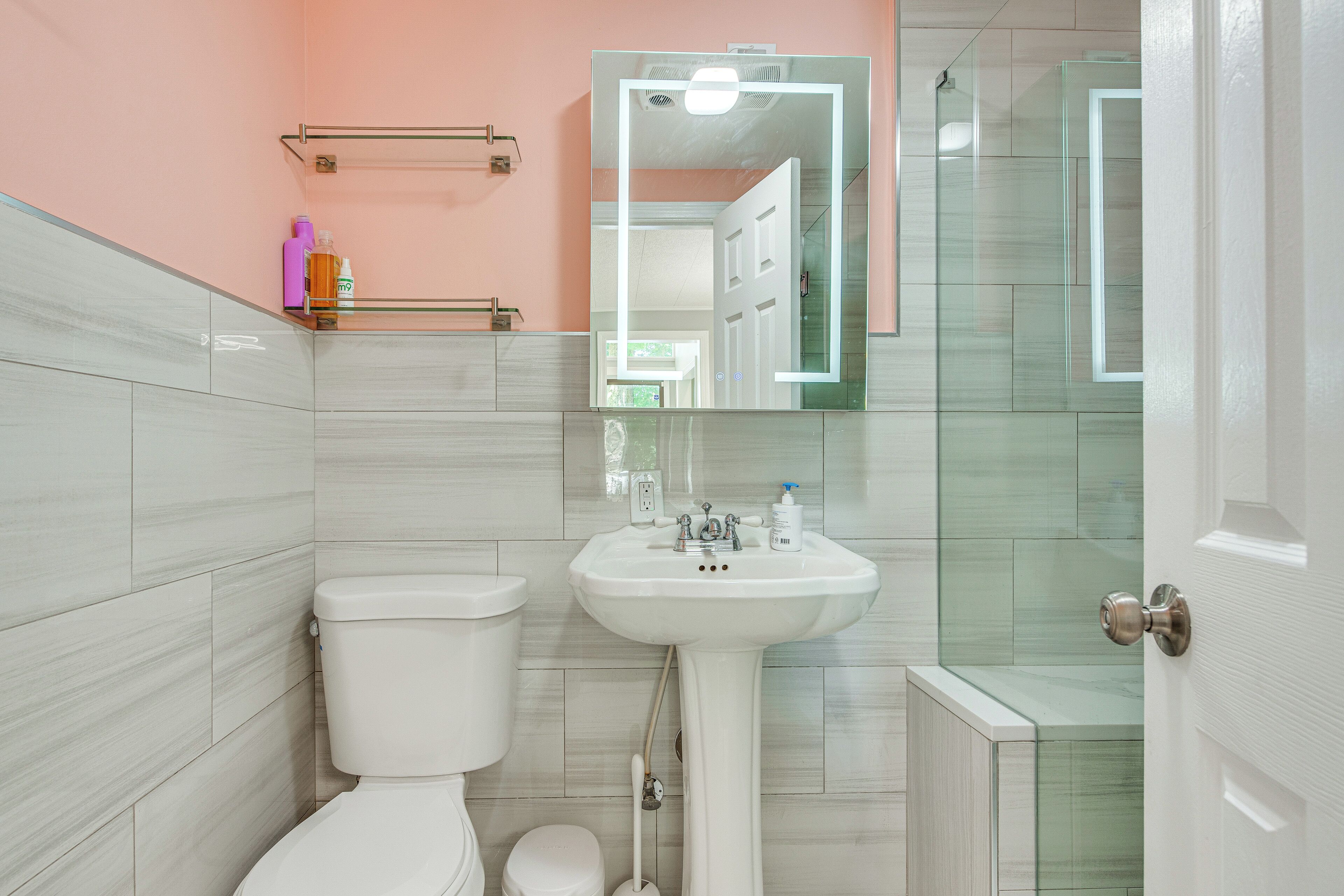 A bathroom with a toilet, sink, and shower area.
