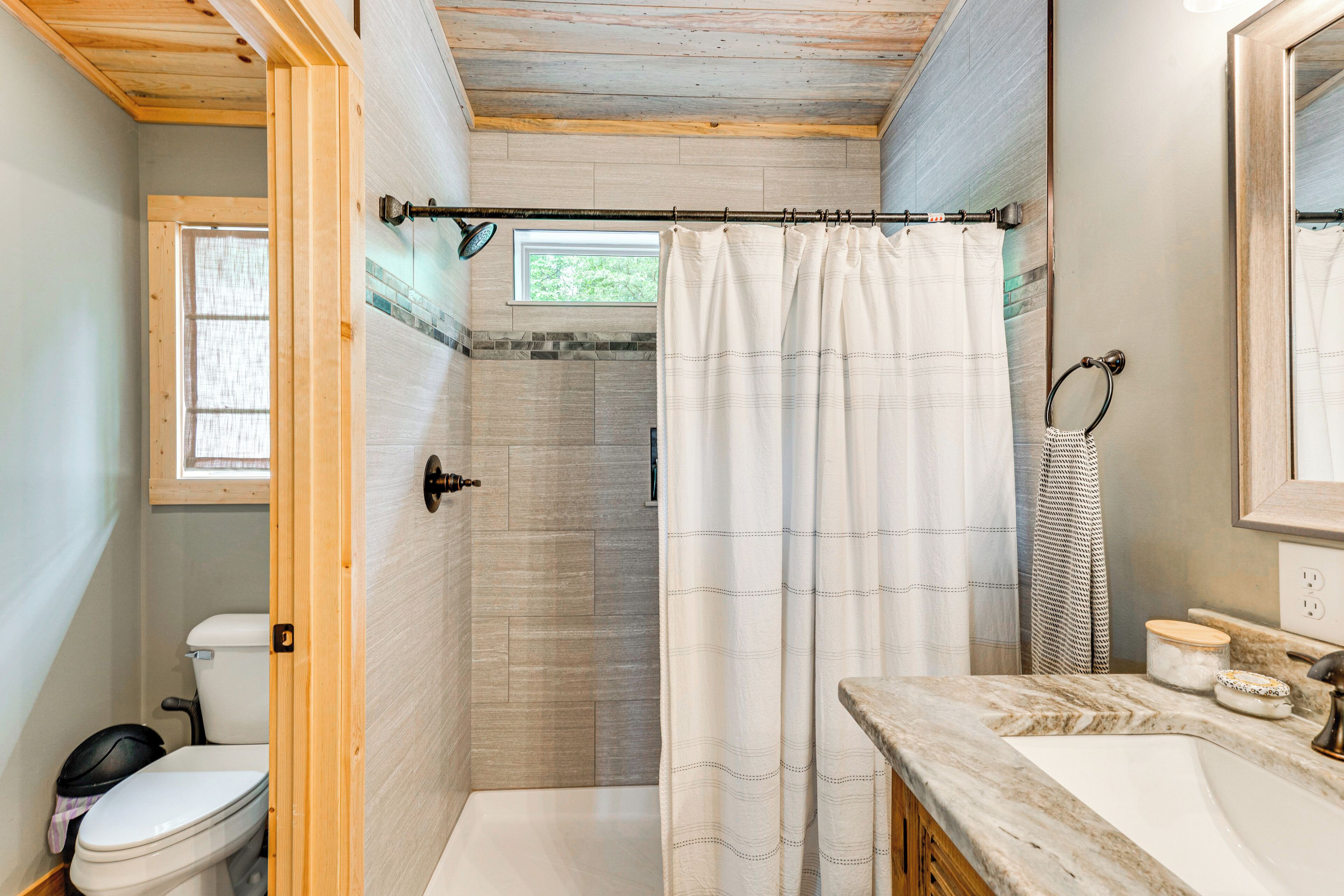 A bathroom with a shower, toilet, and sink.