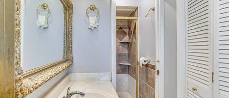 Un baño con un espejo grande, un lavabo y una zona de ducha.