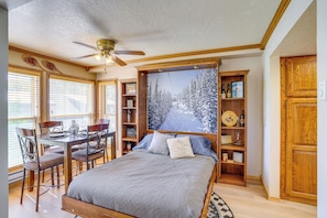 A bedroom with a bed, a desk, chairs, a bookshelf, and a painting of a snowy mountain. - Hiking & Explore: Brian Head Condo w/ Indoor Pool! (Brian Head)