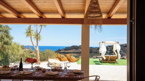 A wooden table set for dining with a view of the sea and hills. - VILLA MAJU (Marina)