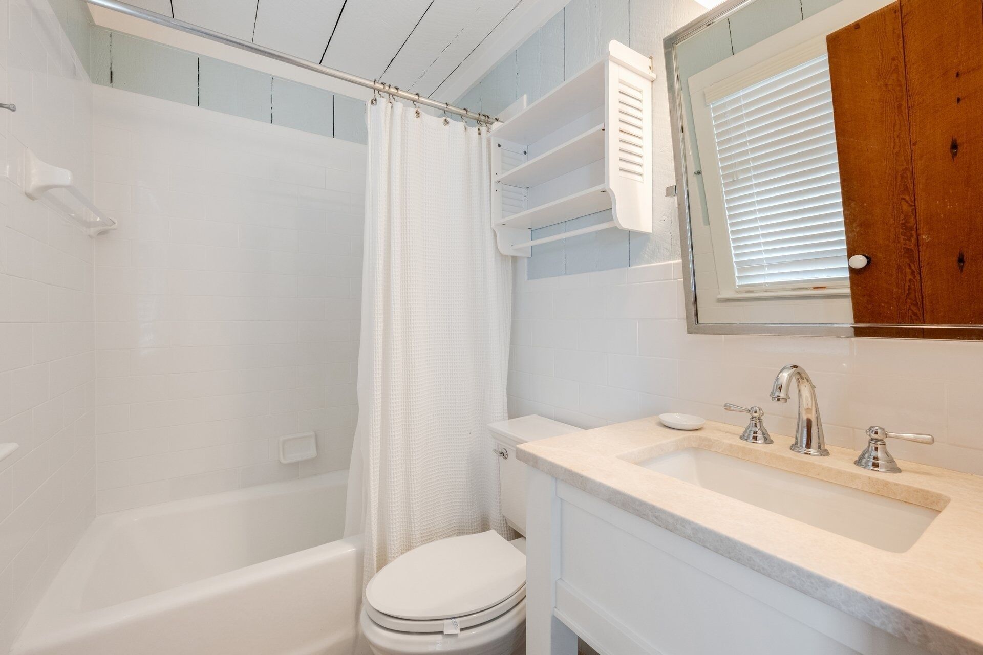 A bathroom with a bathtub, toilet, and sink.