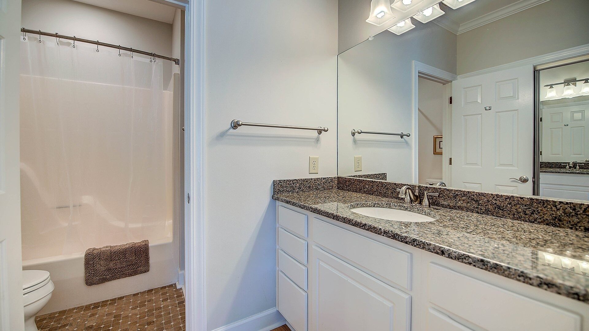 Une salle de bain avec douche, toilettes et lavabo.