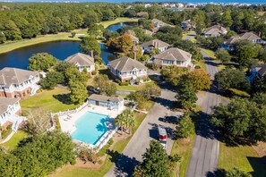 A residential area with houses, a swimming pool, and a lake.