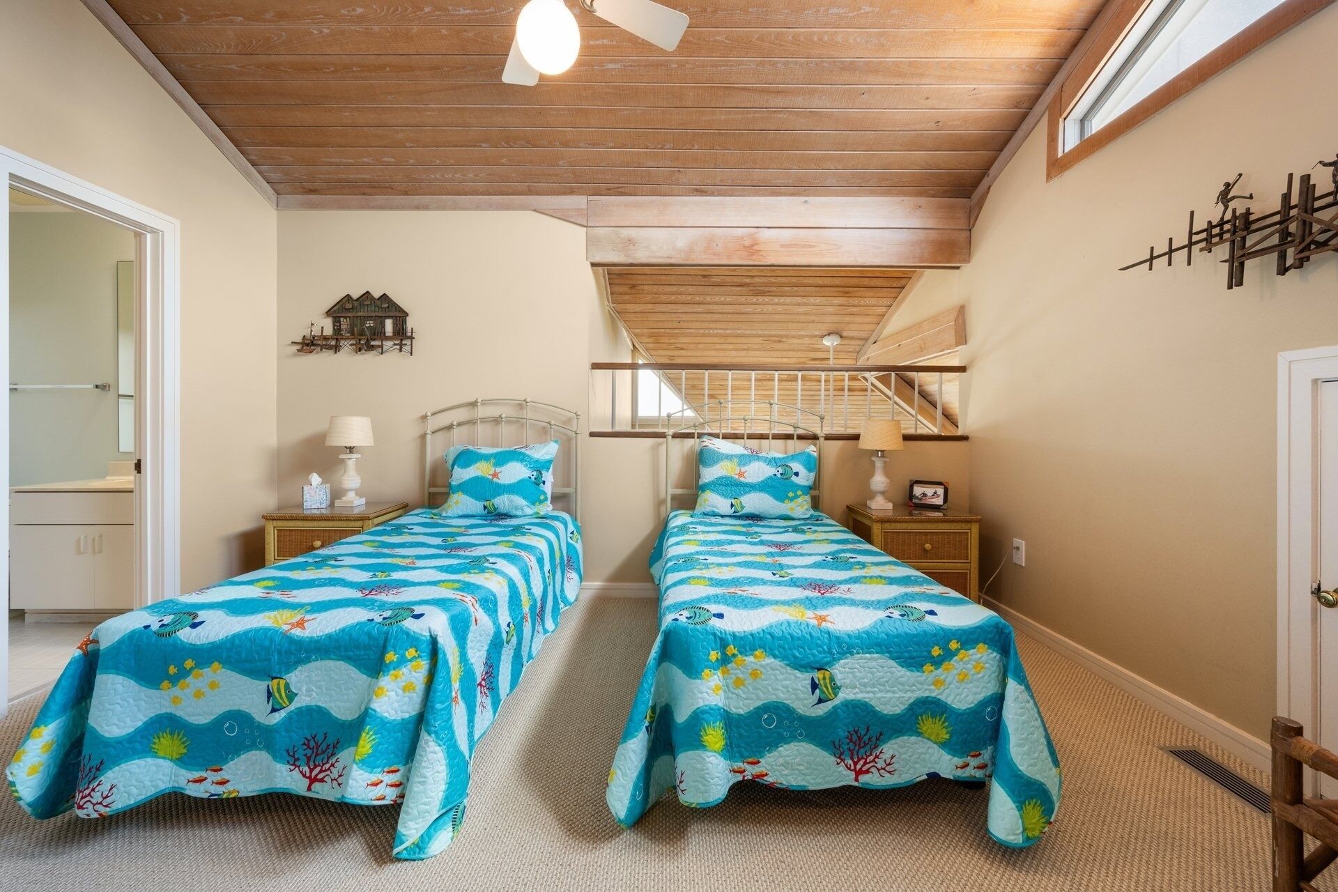A bedroom with two beds, wooden ceiling beams, a small window, and a wall-mounted decoration.