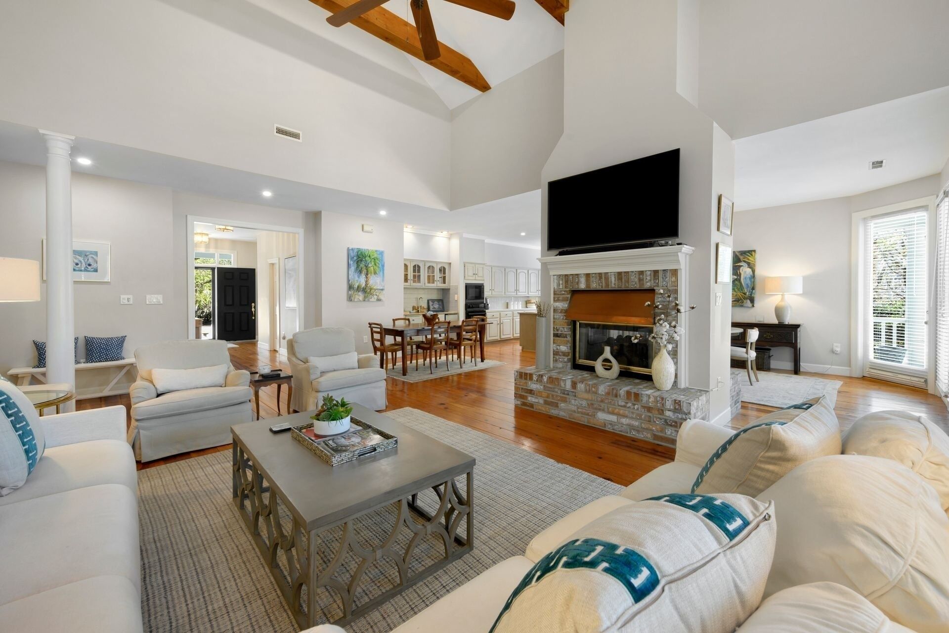 A spacious living room with a fireplace, a dining area, and a kitchen.
