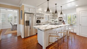A modern kitchen with a marble island, stainless steel appliances, and pendant lighting. - Relax And Enjoy The Spectacular Views In This Picturesque Home 6 Bedroom Home by Peace Vacations (Georgetown)